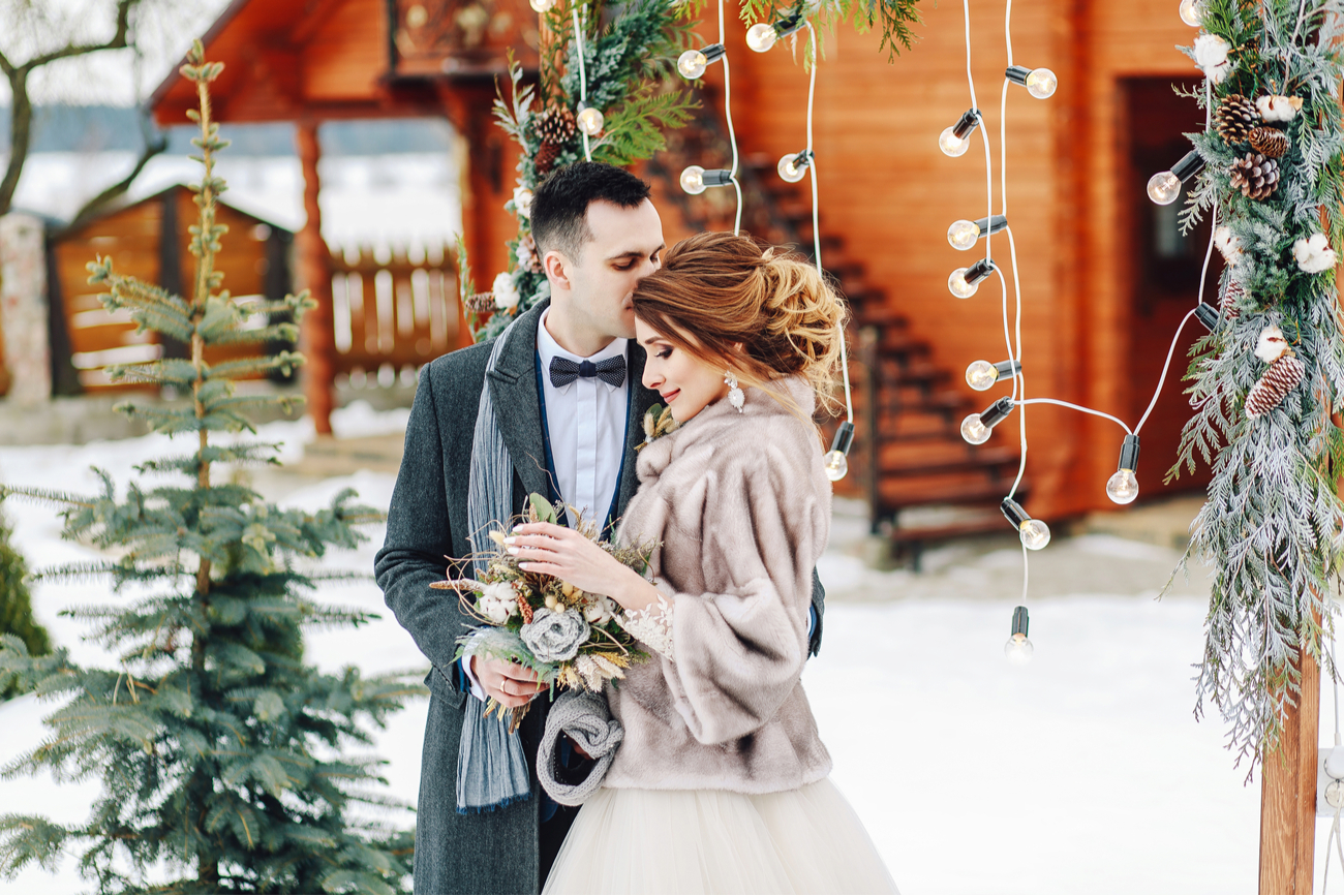 beautiful winter wedding - groom kissing bride during photoshoot