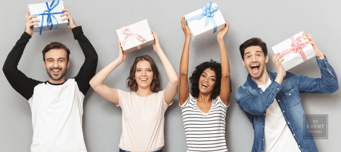 Image of excited group of friends standing isolated over grey wall background holding surprise gift boxes.
