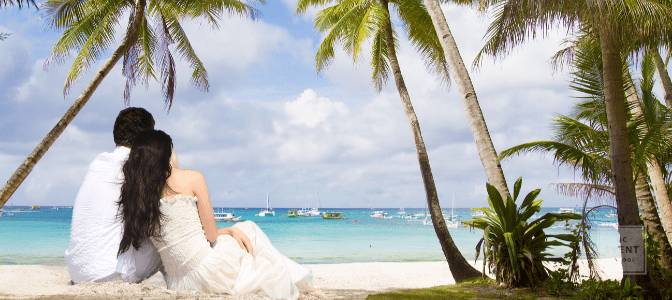 bride and groom on beach looking at ocean