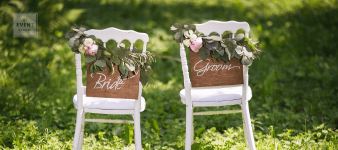 becoming a wedding planner - white chairs in grassy field with bride and groom signs